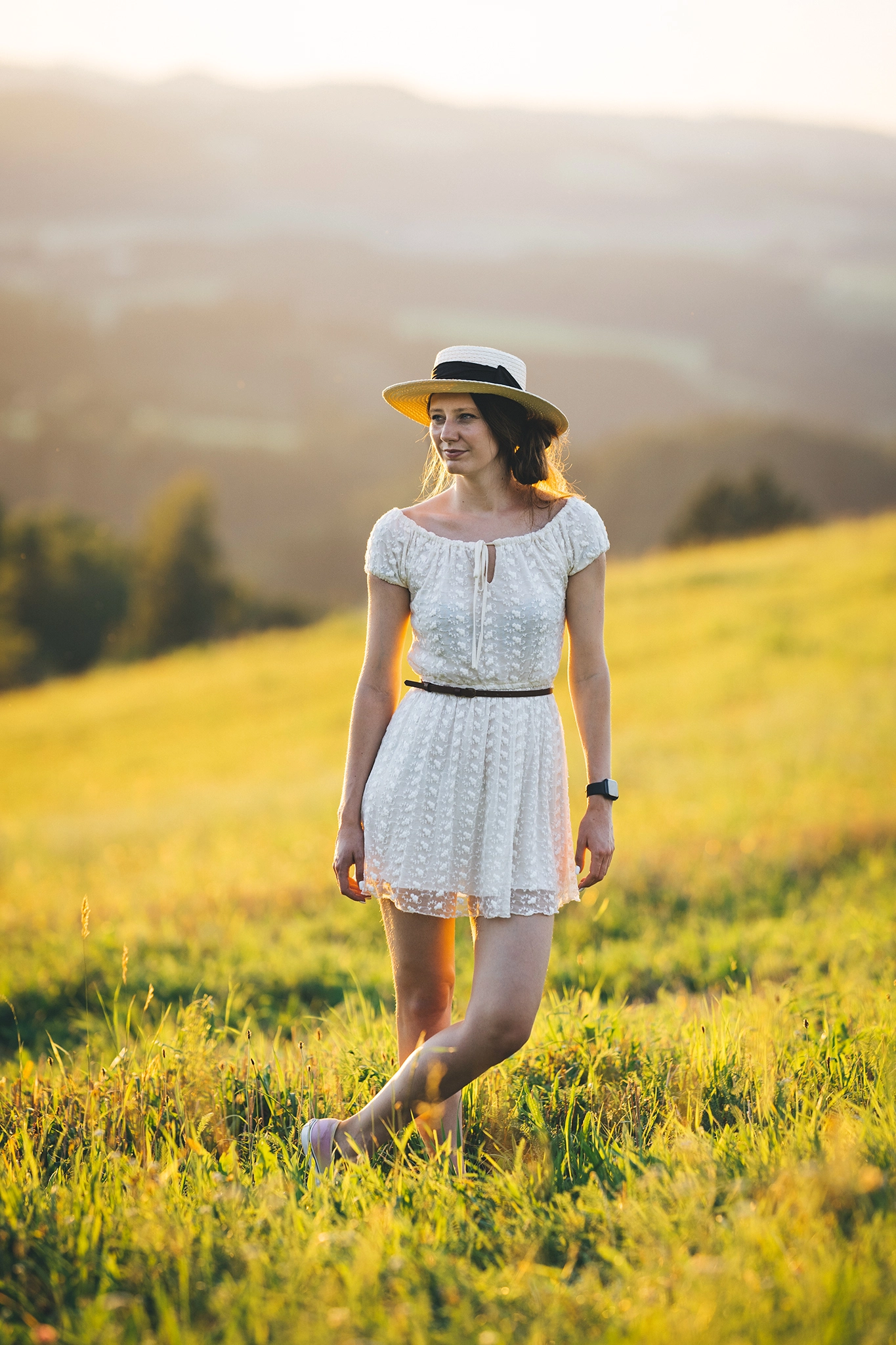 Fotografin in weißem Kleid mit Hut beim Sonnenuntergang am Weinberg in Kefermarkt